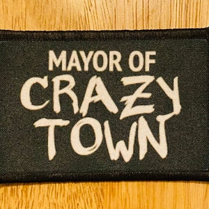 May include: Black fabric patch with white text that reads "Mayor of Crazy Town".