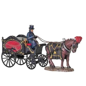 May include: A miniature horse-drawn carriage figurine featuring a black hearse with red interior accents and gold trim. A driver in a blue coat and top hat sits on the front seat. A brown horse with a black harness and red plume pulls the carriage.