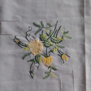 ヴィンテージの大きな長方形の白い刺繍のテーブルクロス。黄色の