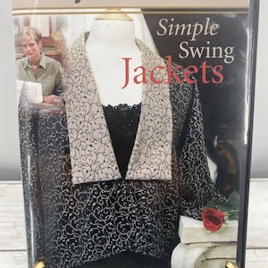 Puede incluir: Un DVD titulado "Simple Swing Jackets" de Nancy Zieman, que presenta una chaqueta con estampado en blanco y negro con ribete dorado y una rosa roja sobre un pedestal blanco.