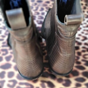 May include: A pair of brown leather ankle boots with a textured pattern. The boots have a pointed toe and a low heel.