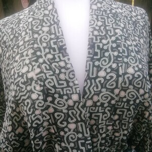 May include: A black and white patterned kimono with a V-neck and a dark green sash.