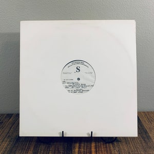 May include: A white vinyl record with black text. The text reads: "1987 Pressing From Specialty Records Corporation", "S", "12 33 1/2 RPM", "Date", "Acct. Atlantic", "To Step Aside", "The Brutale Mir Quiet My", "Artist Pet Shop Boys", "Mix No. 86057-84054", "4C No. 2462".