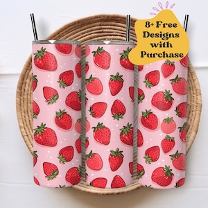 May include: Three stainless steel tumblers with a pink background and a pattern of red strawberries. Each tumbler has a black straw. The text "8+ Free Designs with Purchase" is in a yellow bubble.
