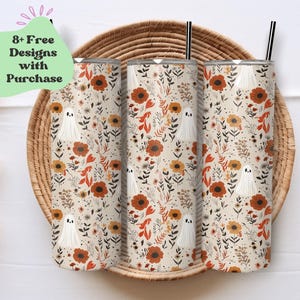 May include: Three stainless steel tumblers with a fall floral and ghost pattern. The tumblers are on a woven basket background. The text "8+ Free Designs with Purchase" is in a green box.