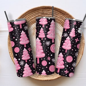 May include: Three stainless steel tumblers with pink and white Christmas trees and candy canes on a black background. The tumblers are sitting in a woven basket.