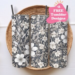 May include: Three stainless steel tumblers with a black and white floral design. The tumblers are sitting on a woven basket. The text '+8 FREE Tumbler Designs' is in a pink speech bubble.