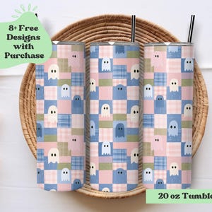 May include: Three cylindrical tumblers with a 20 oz capacity, each featuring a repeating pattern of small white and blue ghosts set against a patchwork background of pink, blue, and green plaid and solid squares, complete with black straws.