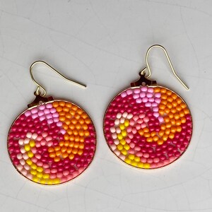 Warm spiral bead disc with gold hoop earrings