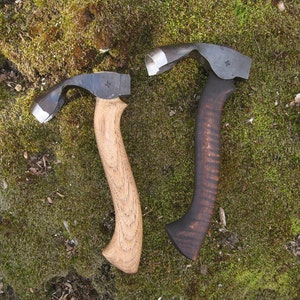 May include: Two wooden handled carving tools with curved blades. The tools are on a bed of green moss.