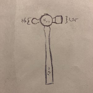 以下が含まれることがあります： 手描きのボールピンハンマーのスケッチ。 ハンマーヘッドには「16 oz」とラベルが付けられ、寸法は1.9 cmと3.2 cmです。 ハンドルには「12インチ」とラベルが付けられ、30.5 cmに相当します。
