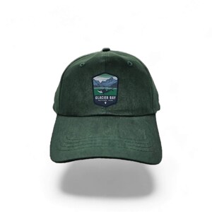 May include: A dark green baseball cap with a patch featuring a landscape and the text "Glacier Bay National Park".