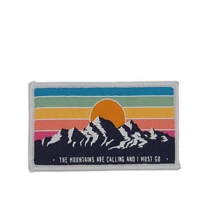May include: A white patch with a colourful sunset and mountain silhouette. The text "THE MOUNTAINS ARE CALLING AND I MUST GO." is printed below the image.