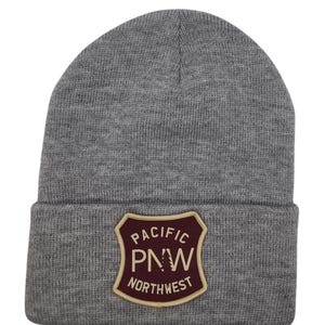 May include: Gray knit beanie with a burgundy and tan patch that says "Pacific PNW Northwest".