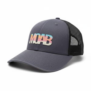 Puede incluir: Gorra de béisbol gris con la parte trasera de malla negra. La palabra "MOAB" está impresa en la parte delantera con un diseño colorido y en capas. La gorra tiene una visera curva y un botón en la parte superior.