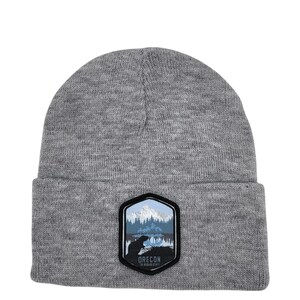 May include: Gray beanie with a black hexagonal patch featuring a mountain range, trees, and a bear. The patch has the text "Oregon The Beaver State" on it.