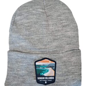 May include: Gray knit beanie with a patch featuring a scenic view of a beach and the text "Virgin Islands National Park".