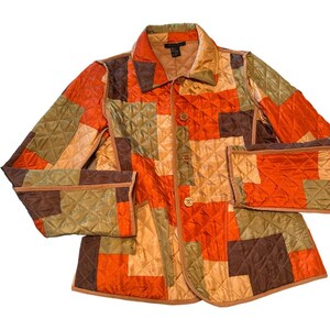 May include: A quilted jacket in a patchwork design featuring squares of orange, brown, and olive green. The jacket has a collared neckline, button closure, and two front pockets. The jacket is a size medium.