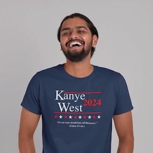 Puede incluir: Una camiseta azul marino con una impresi&oacute;n blanca que dice "Kanye West 2024" con estrellas rojas y el texto "No one man should have all that power. (Unless it's me.)"