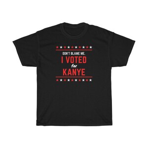 May include: Black t-shirt with red text that reads "Don't blame me. I voted for Kanye."  The text is surrounded by red stars.