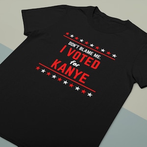 May include: Black t-shirt with white text that reads "Don't blame me. I voted for Kanye" with red stars.