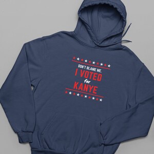 May include: A navy blue hoodie with a white print that says "DON'T BLAME ME. I VOTED for KANYE" with stars above and below the text.