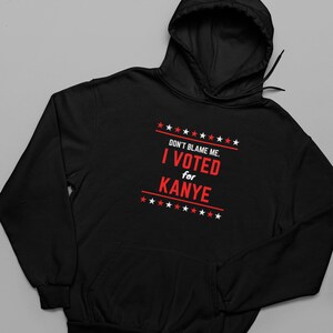 May include: Black hooded sweatshirt with a red graphic that says "Don't blame me. I voted for Kanye" with stars above and below the text.