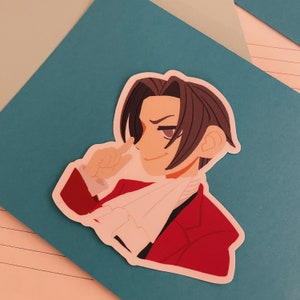 May include: A cartoon sticker of a man with brown hair wearing a red jacket and a white scarf. He is smiling and has his finger to his lips.