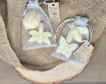 May include: Two small white organza bags filled with small white soap favors shaped like a butterfly, dragonfly, and bee. The bags have thank you tags attached with the text "Thank You" and "Sarah's Baby Shower 06.20.2023".