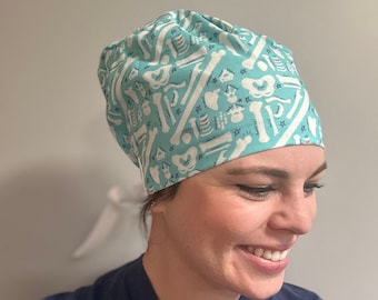 May include: A turquoise scrub hat with a white bone pattern. The hat is made of a soft, comfortable fabric and is perfect for healthcare professionals.