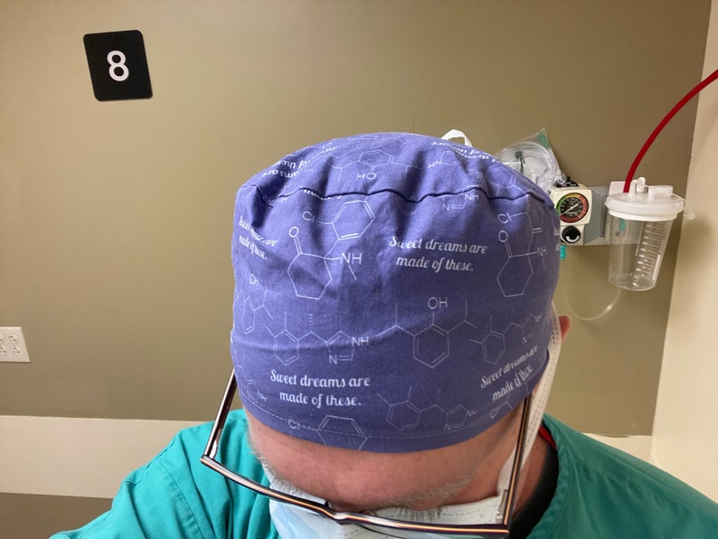 May include: A blue surgical scrub hat with a white print of chemical structures and the text "Sweet dreams are made of these."