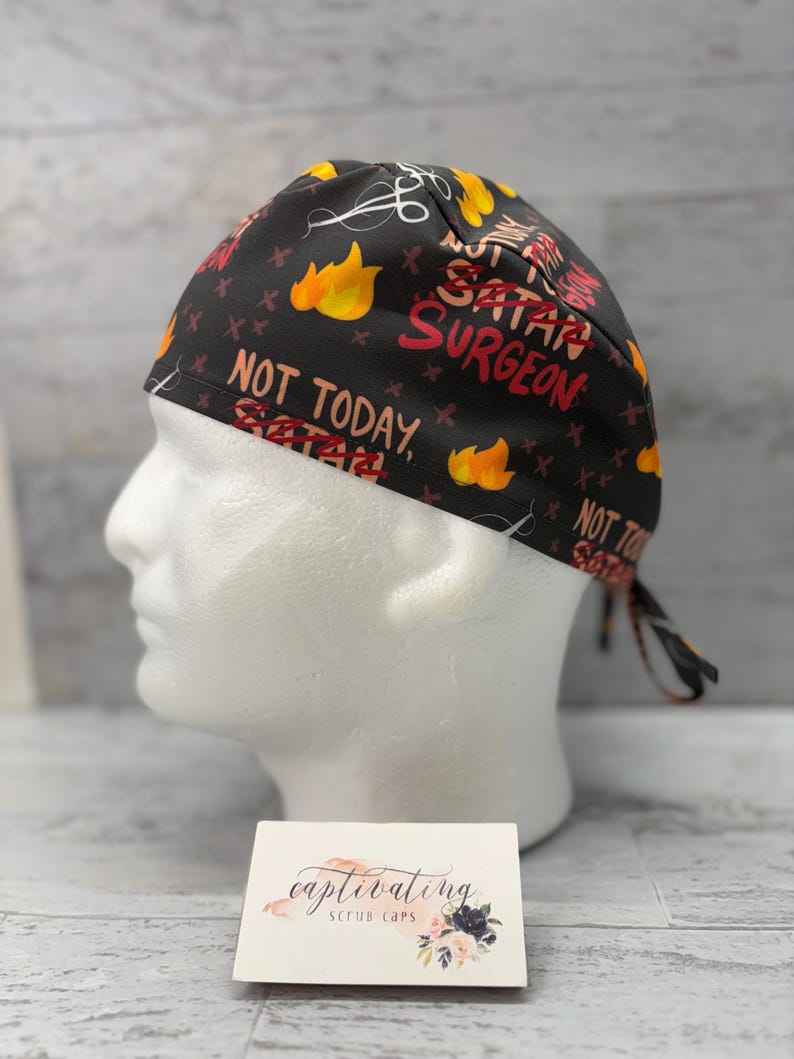 May include: Black scrub cap with a red and yellow print that says "Not Today, Satan" and "Satan Surgeon".