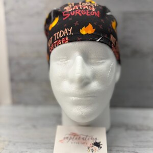 May include: Black scrub cap with a colorful print that says "Not Today, Satan Surgeon".
