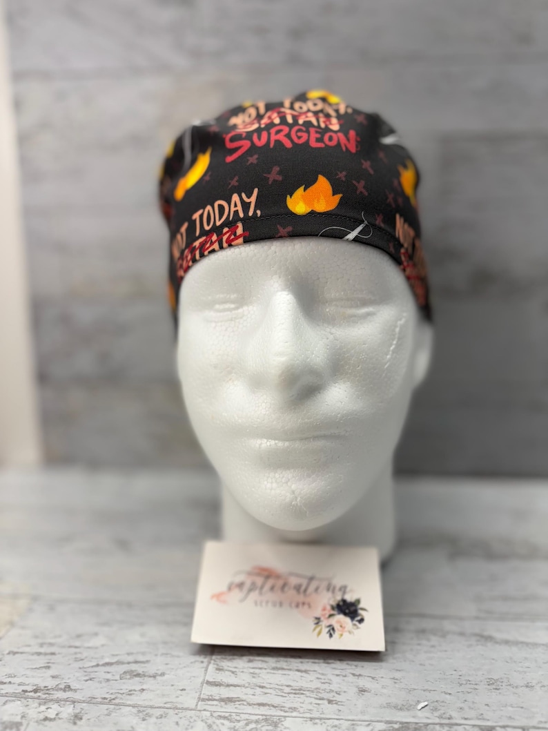 May include: Black scrub cap with a colorful print that says "Not Today, Satan Surgeon".