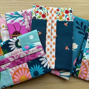 May include: A collection of rectangular fabric tissue holders featuring various colorful patterns including floral prints, geometric shapes, and mushroom motifs. The holders are constructed from cotton fabric with contrasting panels, checkered strips, and vibrant color palettes.