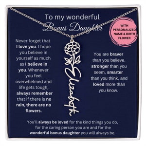 May include: A silver necklace with a flower charm and the name "Elizabeth" engraved on it. The necklace comes in a blue box with a message that reads "To my wonderful Bonus Daughter. Never forget that I love you. I hope you believe in yourself as much as I believe in you. Whenever you feel overwhelmed and life gets tough, always remember that if there is no rain, there are no flowers. You are braver than you believe, stronger than you seem, smarter than you think, and loved more than you know. You'll always be loved for the kind things you do, for the caring person you are and for the wonderful bonus daughter you will always be."