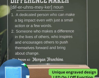 May include: Personalized wooden plaque with a white inscription that reads "Difference Maker" and defines the word as "a dedicated person who can make a big impact even with just a small action or a few words." The plaque has a built-in LED light that can be turned on or off.
