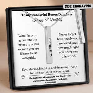 May include: A silver-colored vertical bar necklace with a chain, presented in a black gift box. The bar is engraved with "Proverbs 31:25" and the box contains a message for a bonus daughter. The text includes "Happy 12th Birthday".