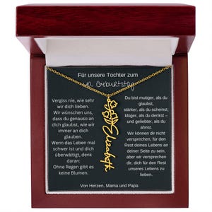 a wooden plaque with a gold necklace on it