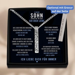 The image is a necklace with a pendant that contains a message in German. The message is in German and is written in a box, which is placed on a black background. The necklace is silver and has a chain attached to it. The message on the necklace reads "An Menen Sohn Vergiss me Wieder Sehr Ich Dich Liebe" and "Ich liebe dich für immer".