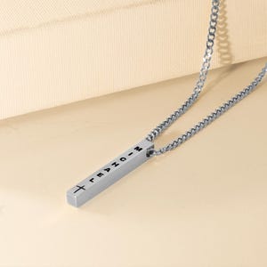 a silver necklace with a cross on it