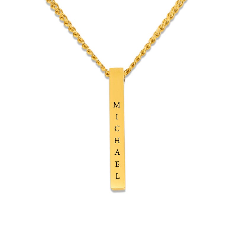 A gold-colored necklace with a rectangular pendant that has the name "Michael" engraved on it.