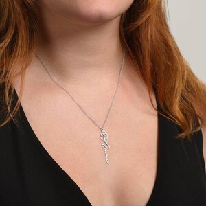 a woman wearing a necklace with a cross on it