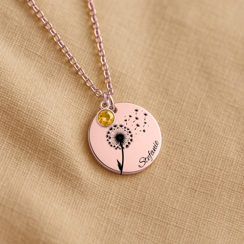 A necklace with a pendant featuring a dandelion design and a yellow gemstone.