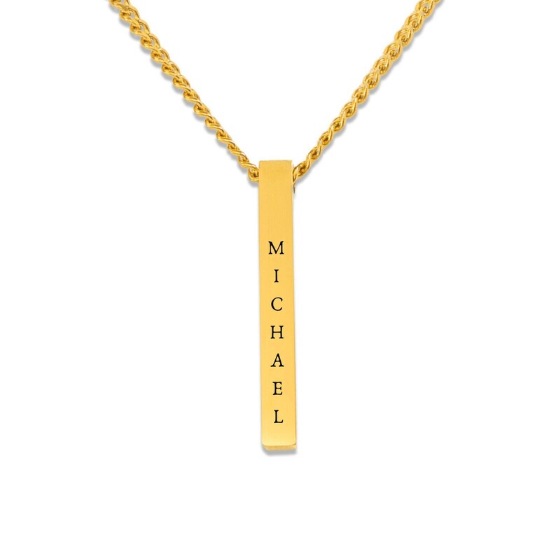 A gold-colored necklace with a rectangular pendant that has the name "Michael" engraved on it.