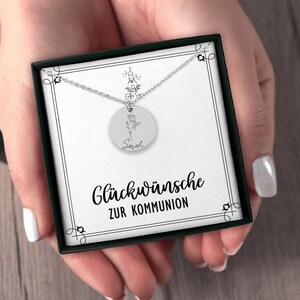 a woman's hands holding a necklace with a picture on it