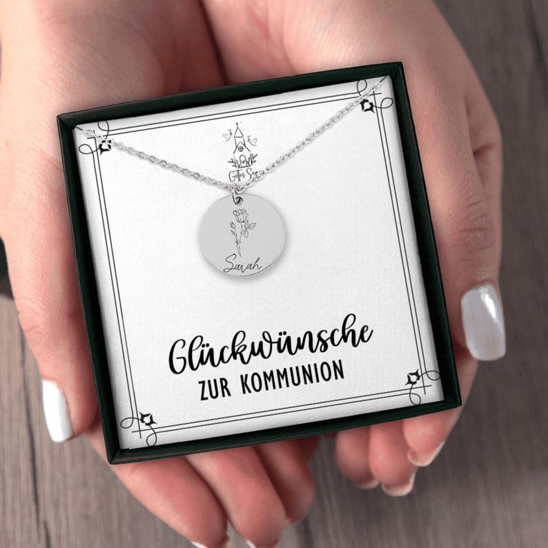 a woman's hands holding a necklace with a picture on it