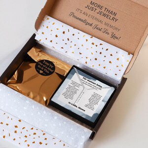an open box containing a necklace and a card