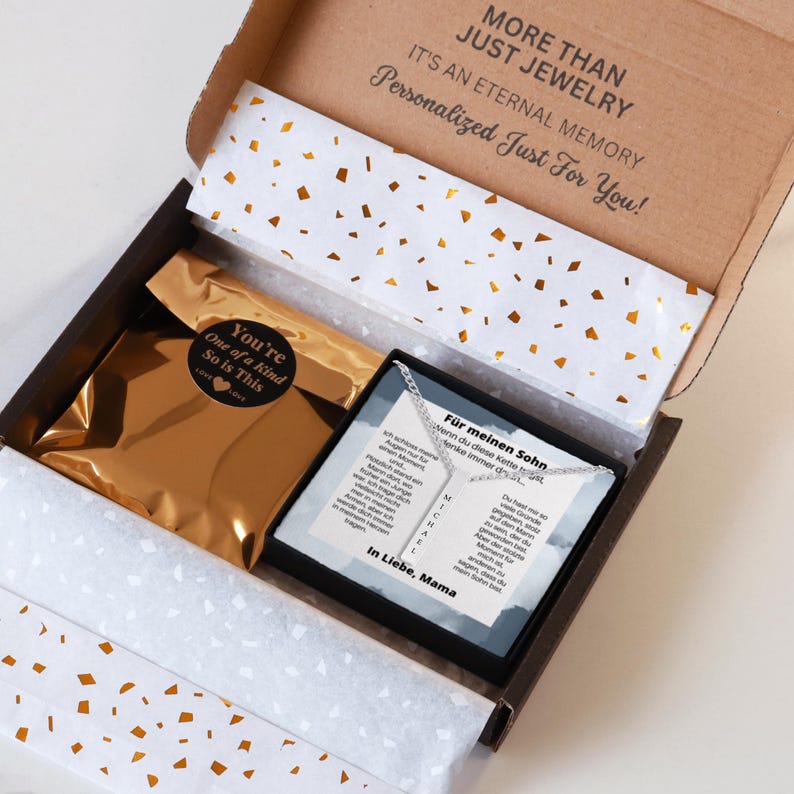 an open box containing a necklace and a card
