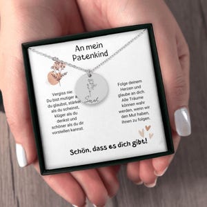 a woman's hands holding a necklace in a box